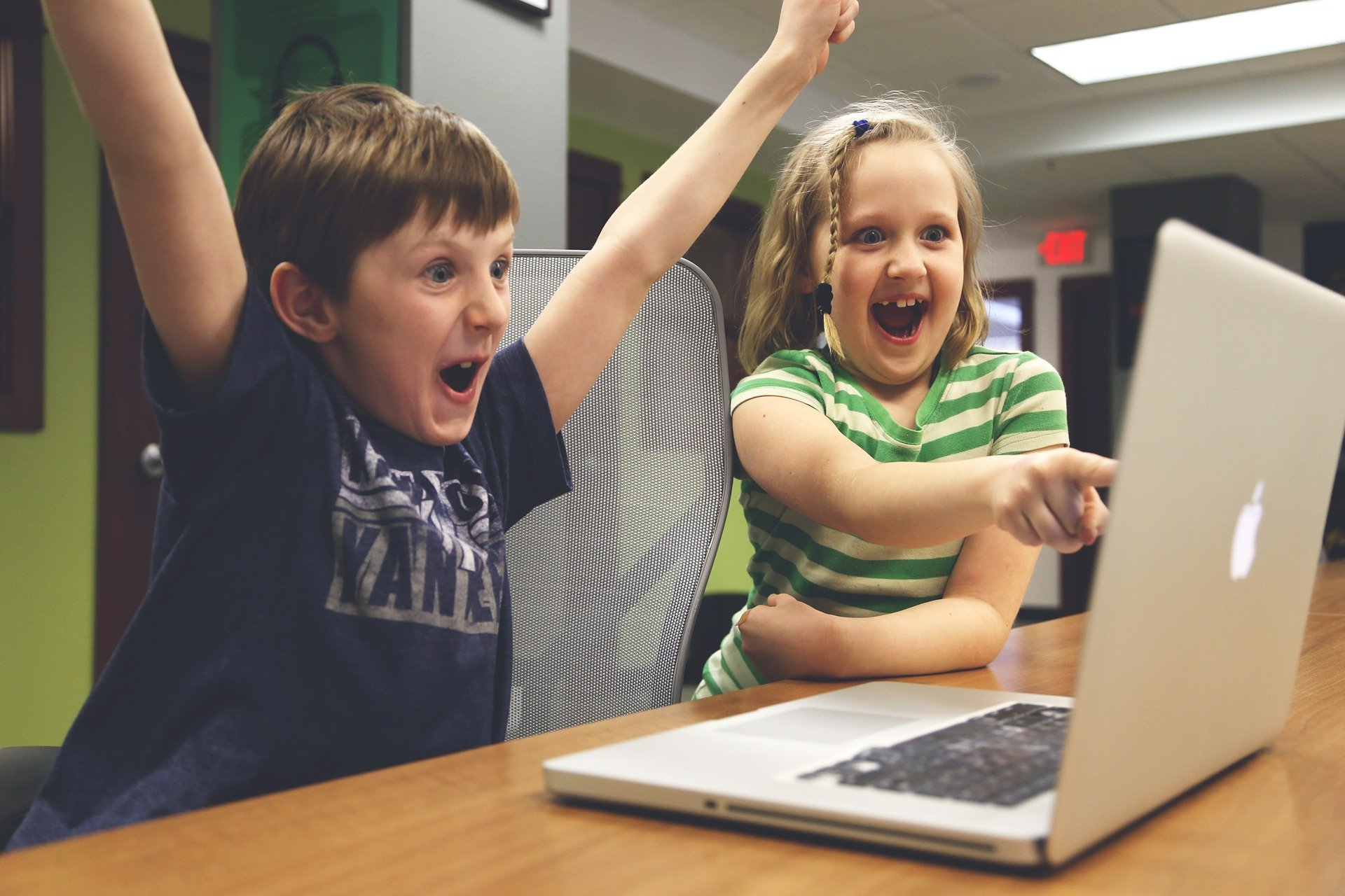 dwoje dzieci przed komputerem, źródło: https://pixabay.com/pl/photos/dzieci-wygrana-sukces-gry-wideo-593313/